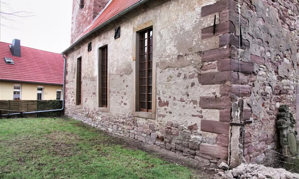 Nordfassade des Kirchenschiffs: abgängiger Verputz und durch offene Fugen geschädigtes Sockelmauerwerk, Februar 2020